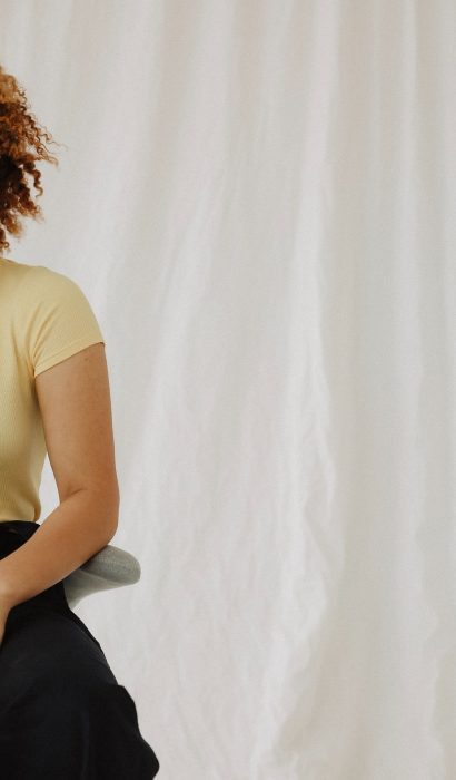 woman-in-beige-t-shirt-beside-wall