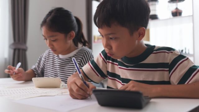 Asian elementary school children studying mathematics in class intently. Asian elementary school children studying mathematics in class intently.