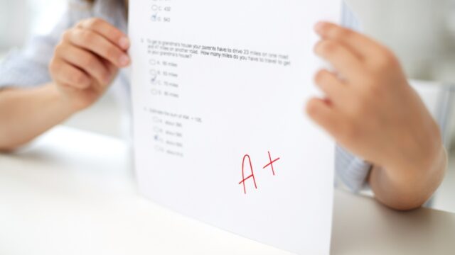 girl with test paper at school education, people, children and learning concept - girl with test paper at school